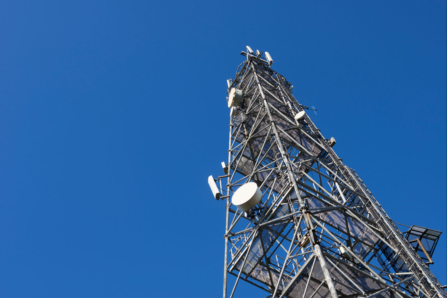 Telecommunication tower with clear blue sky background. Antenna on blue sky. Radio and satellite pole. Communication technology. Telecommunication industry. Mobile or telecom 4g and 5g network.
