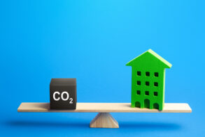 Residential building and CO2 emissions on scales. Greenhouse gas Emissions. Improving energy efficiency, lowering impact on environment.
