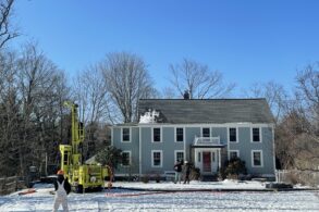 A house in winter with drill for geothermal well