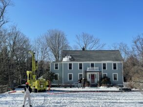 A house in winter with drill for geothermal well