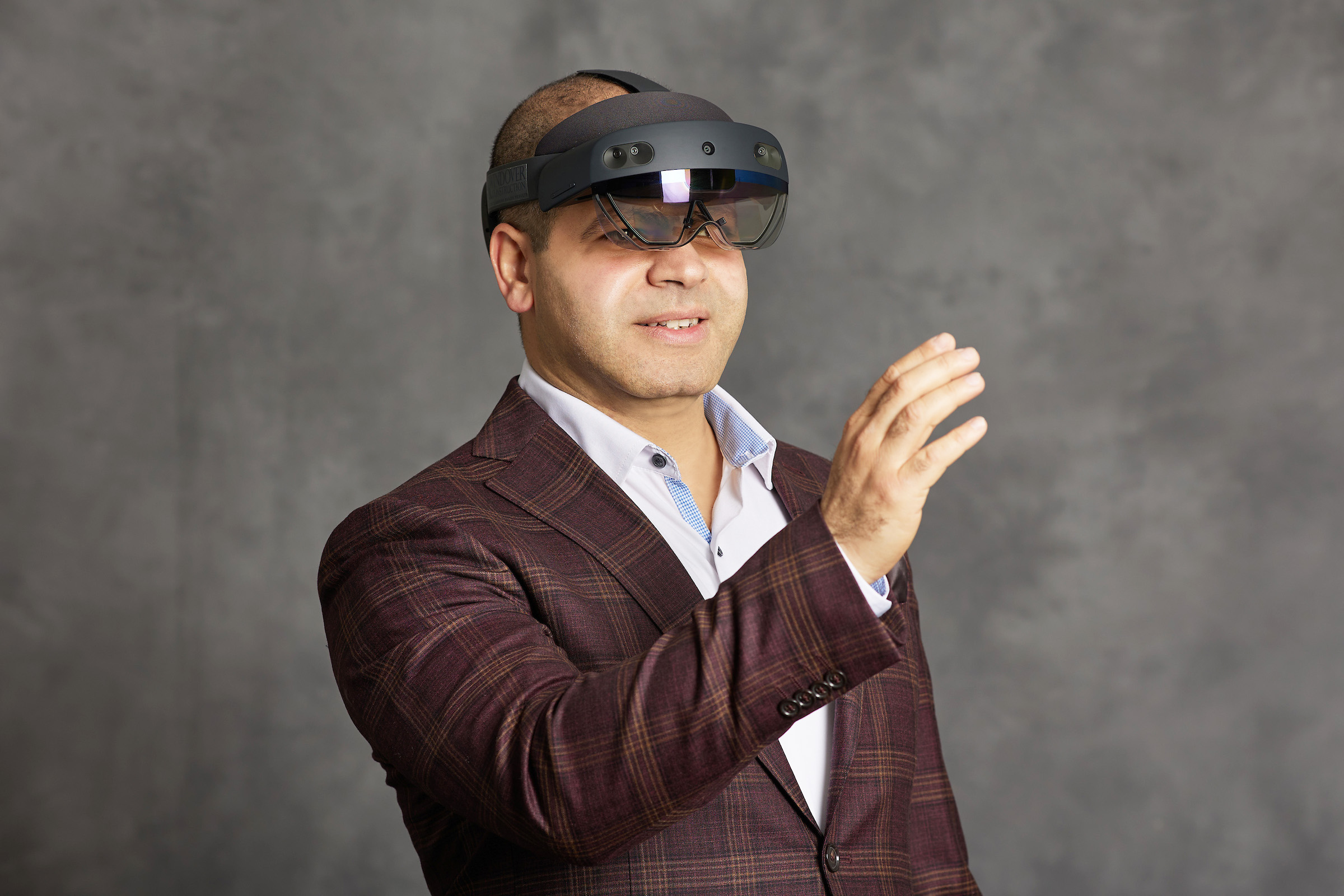 Amr Raafat holds out his arm while wearing a VR headset