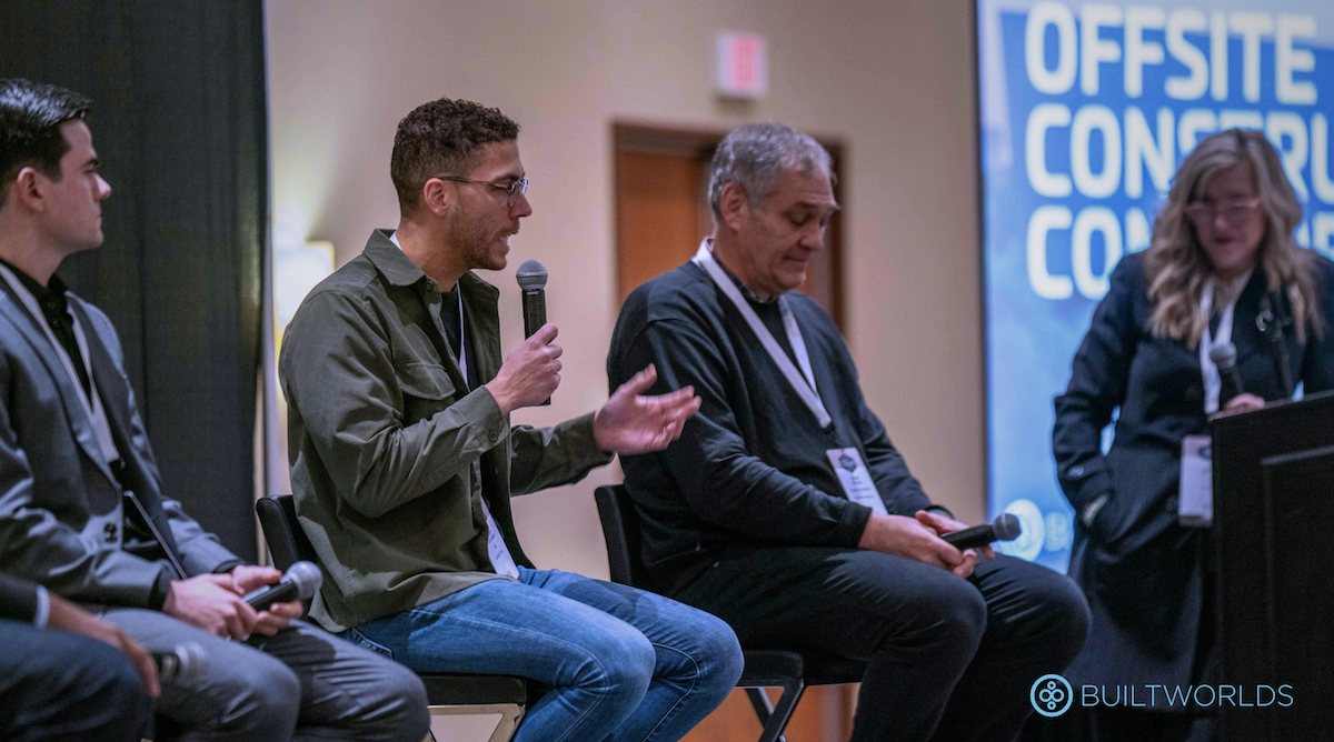 Andrew Staniforth (CEO Assembly OSM) speaks at Offsite Construction Conference 2024. A man speaks into a microphone flanked by other people on a panel. 