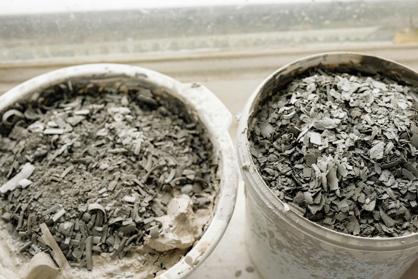 Two buckets of gray concrete chips and other construction waste. 