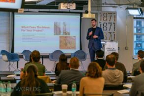 Man in business attire pitches construction financial technology startup to investors and audience