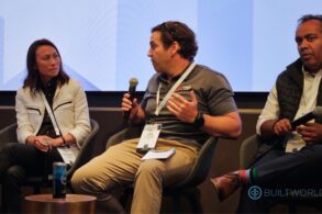 Three speakers talk amongst themselves on a business conference panel.