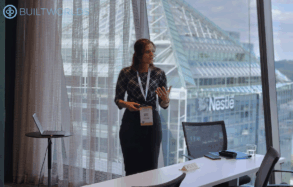 Professional woman leads discussion in front of view during the 2025 Infrastructure Conference by BuiltWorlds