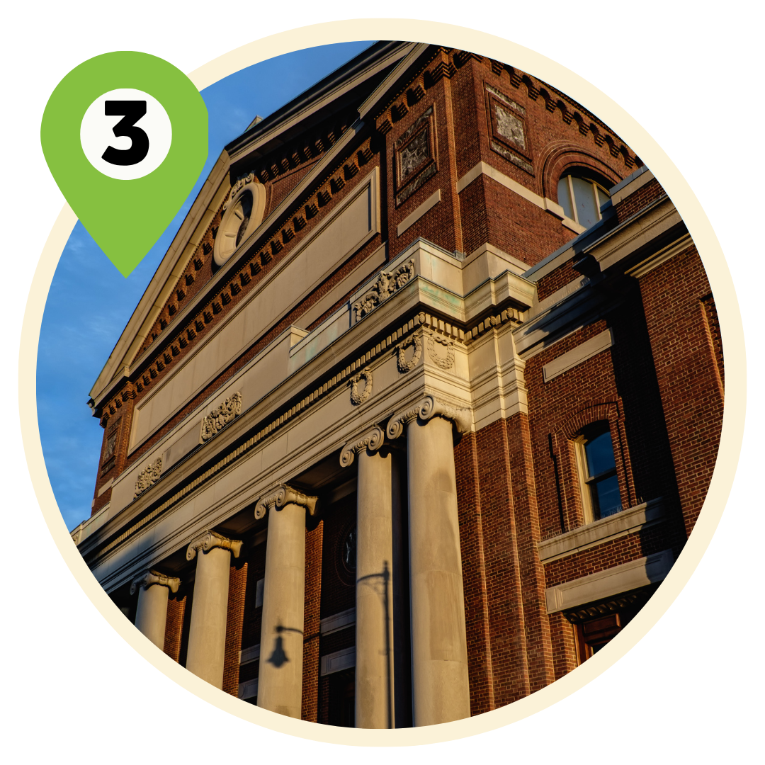 A Greco-Roman revival facade features five columns of white stone against red bricks. Image features exterior shot of Symphony Hall in Boston
