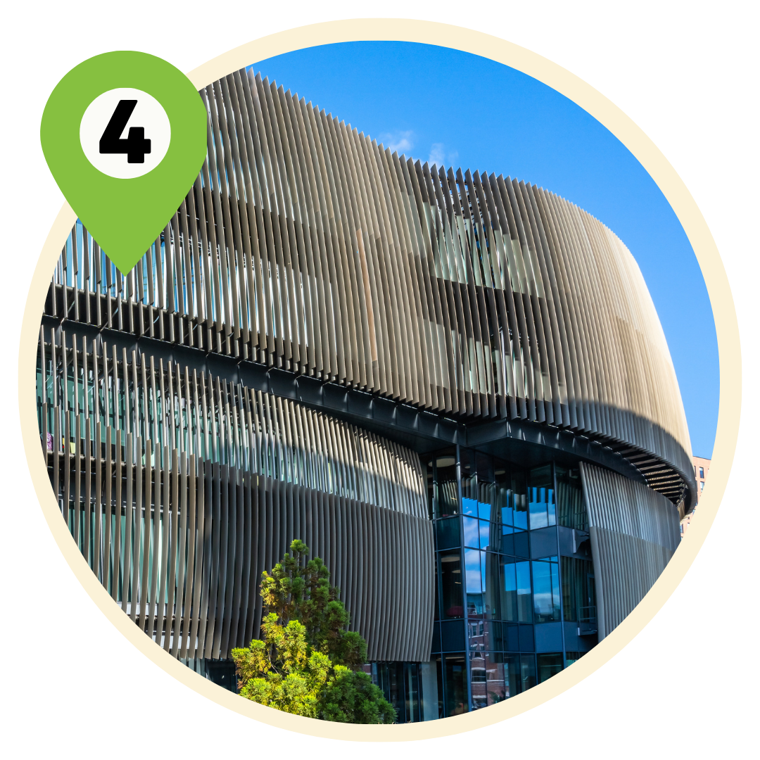 An exterior shot of the Northeastern University ISEC building, which features a curved exterior wall lined with small metal slats.