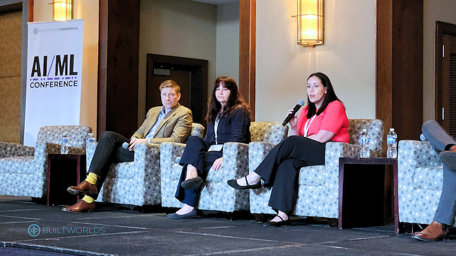 Two women and one man sitting in plush chairs on stage speaking