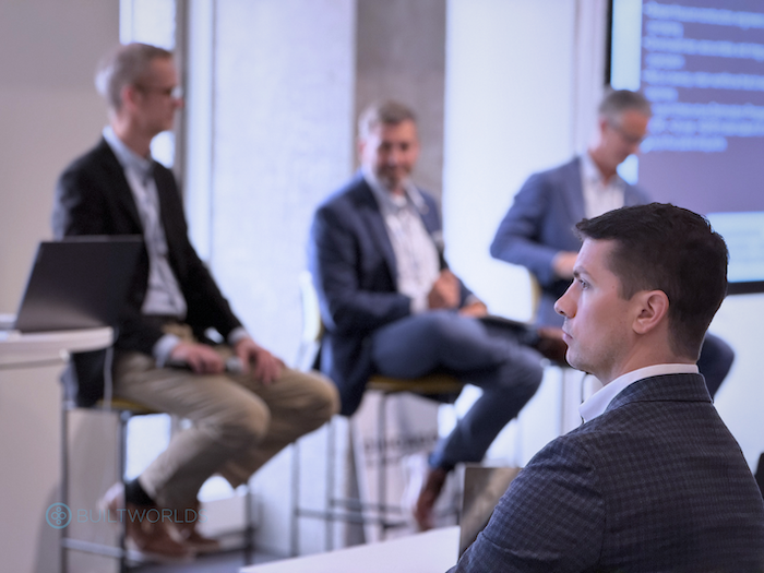 man watching experts on stage at the 2026 Chicago Global Summit conference put on by BuiltWorlds